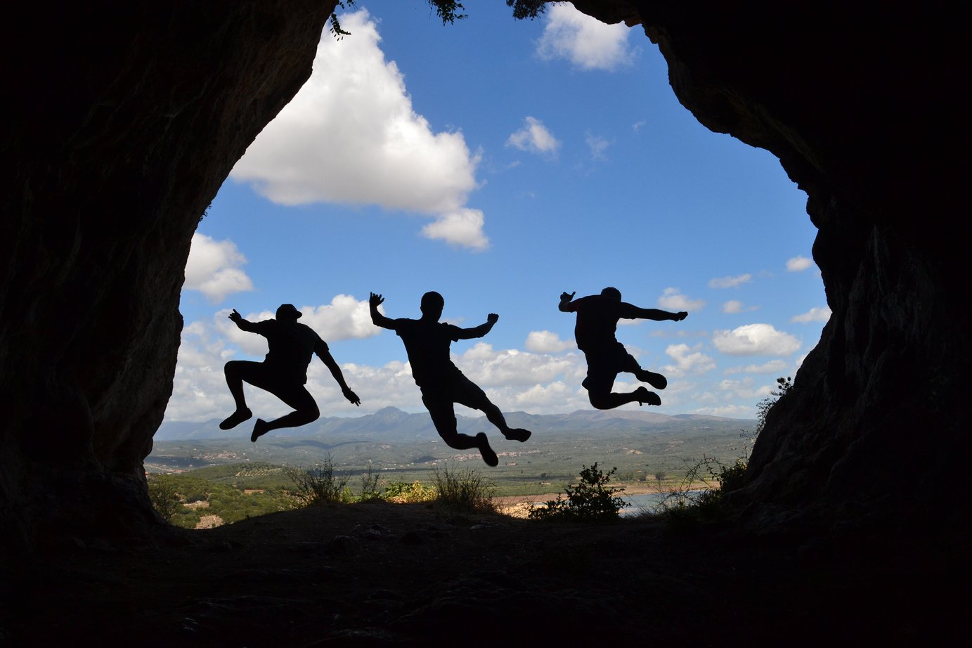 Silhouette of Friends Jumping in the Cave